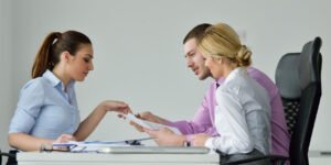 Coworkers at desk explaining paperwork to each other